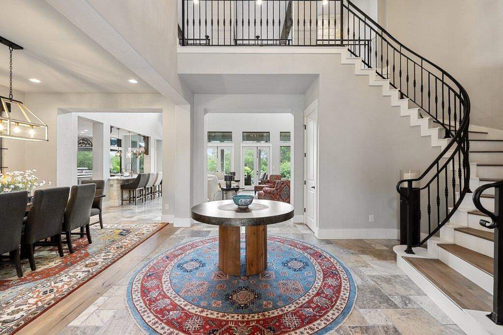 A grand entrance welcomes you into an inviting home with an elegant staircase and open concept living.