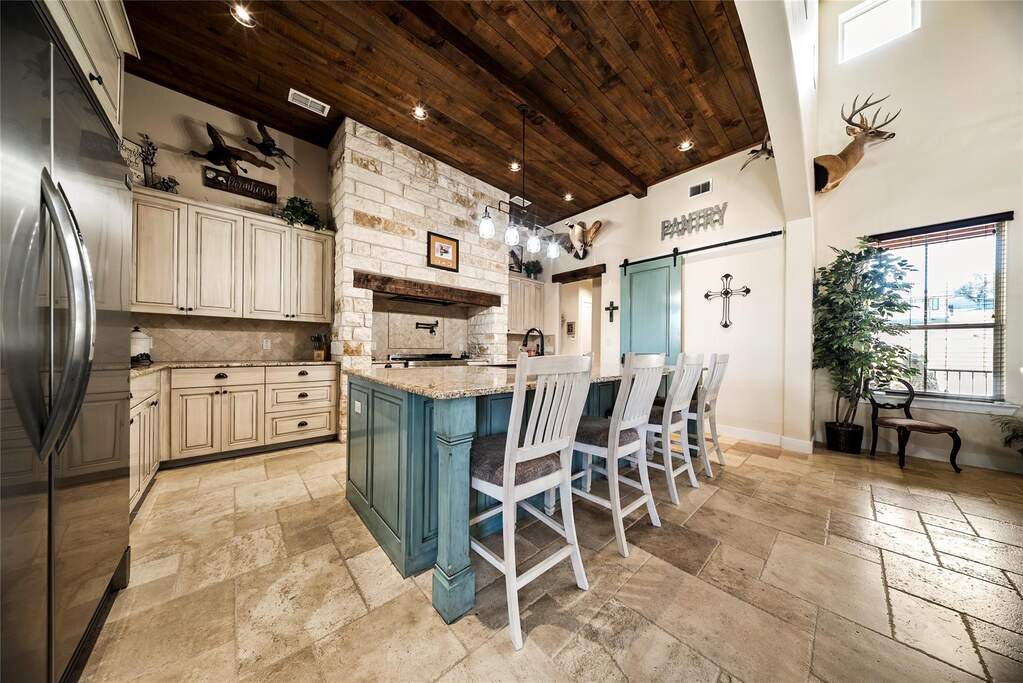 Chef-inspired kitchen with large center island, wood and beam accents