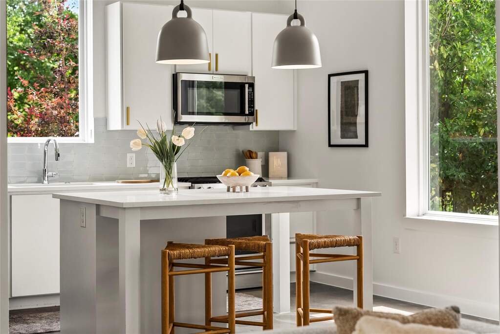 The kitchen is a chef’s dream, centered around a quartz island with plenty of room for friends to pull up a stool.