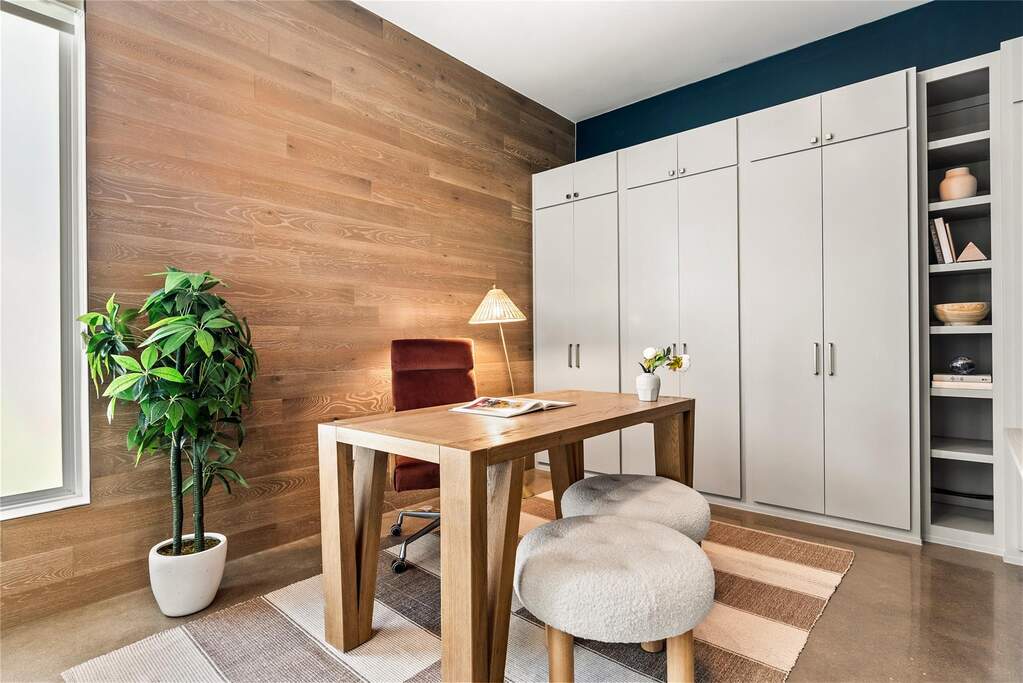 This main-level bedroom is incredibly flexible, offering a quiet, private setup for a dedicated workspace or a guest suite