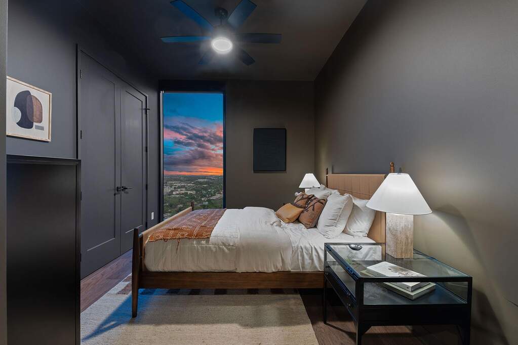 Representative Photo. Primary Bedroom with wood flooring, large window, ceiling fan, and window treatments included