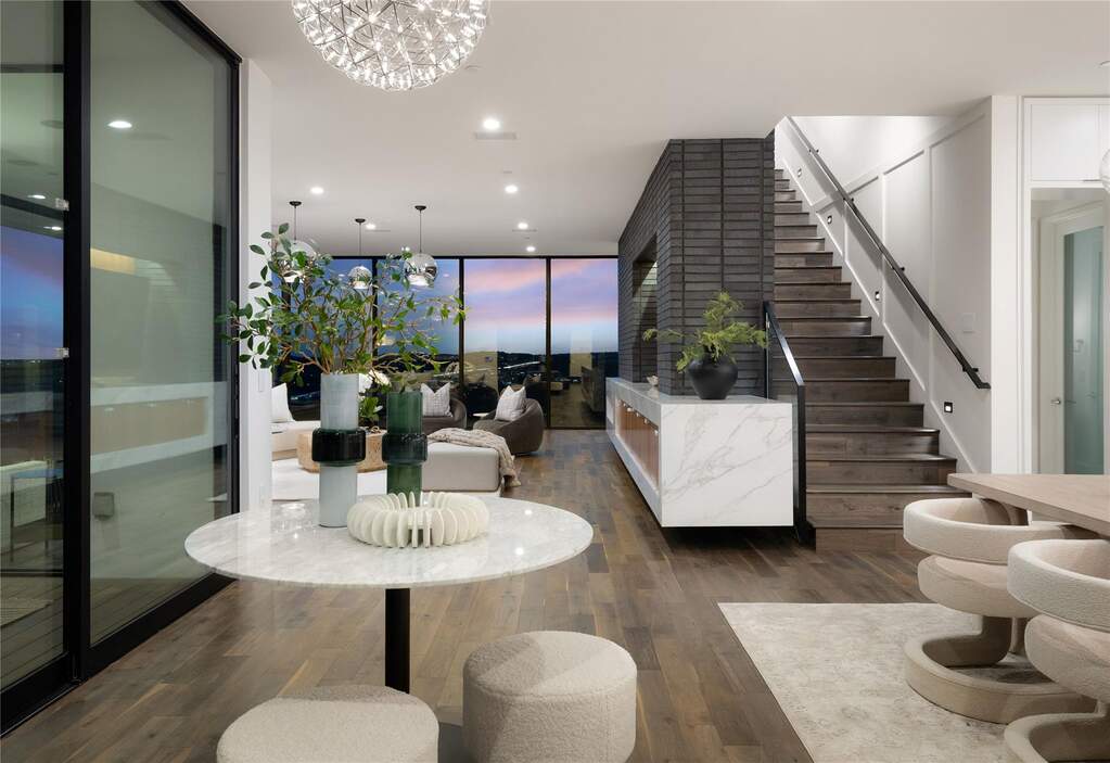 As you step through the front door, the home opens in a measured way, drawing your eye outward to the views beyond while the scale and finishes quietly introduce themselves