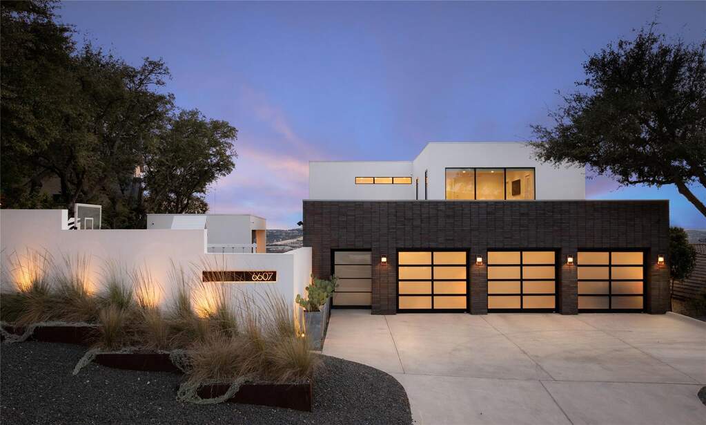 You notice the architecture first with its balanced proportions and a three-car garage that’s integrated so seamlessly it feels like part of the design, not an afterthought.