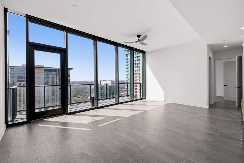 Open Concept living room with 7.5" wide Bella Cera hardwood flooring, recessed lighting, ceiling fan, and a balcony off the living room with a stunning South view
