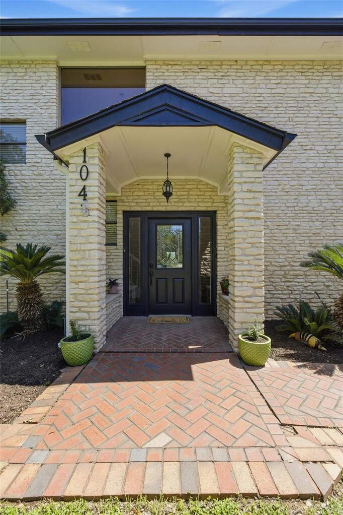 Grand entrance with cobblestone pathway to glass entry door