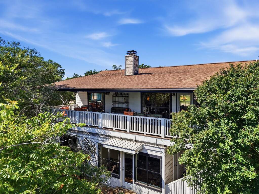 Back of home with upper deck that spans the length of the home.