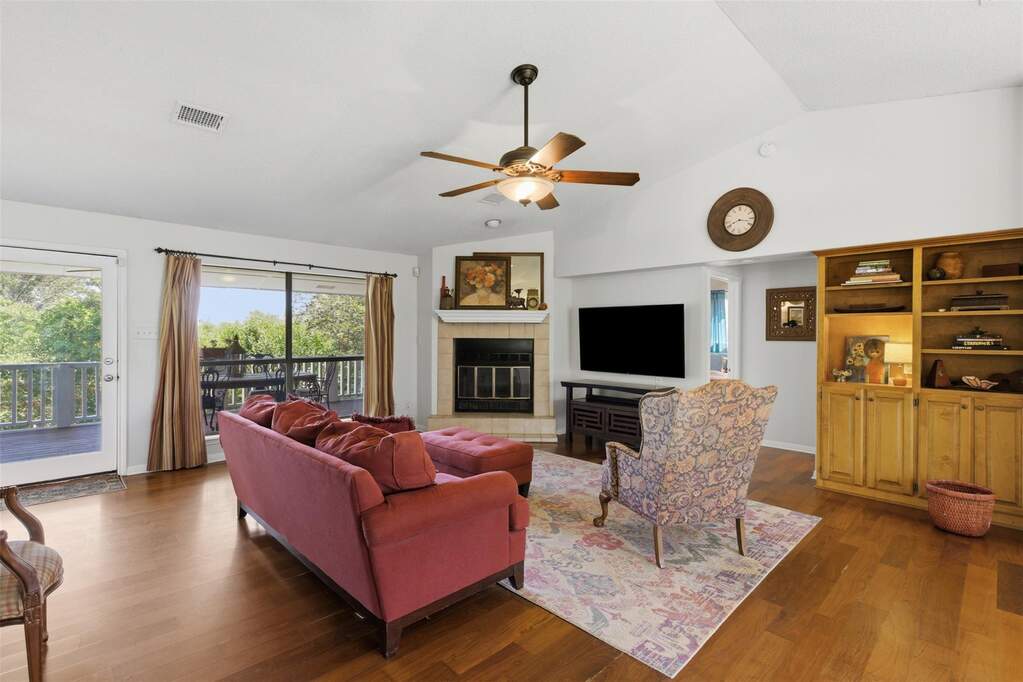 Hardwood floors, fireplace and numerous windows for a grand view of the lush backyard