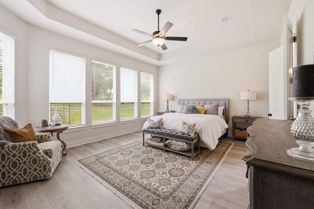 The primary suite serves as a private, sun-drenched wing of the home, featuring a wall of windows that lets you wake up to peaceful views of nature