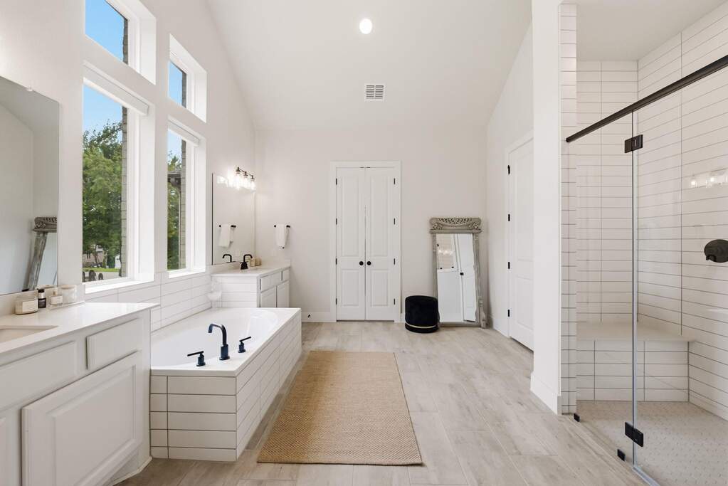 The primary ensuite bath offers a spa-like escape right at home, complete with separate vanities, a soaking tub and a large walk-in shower