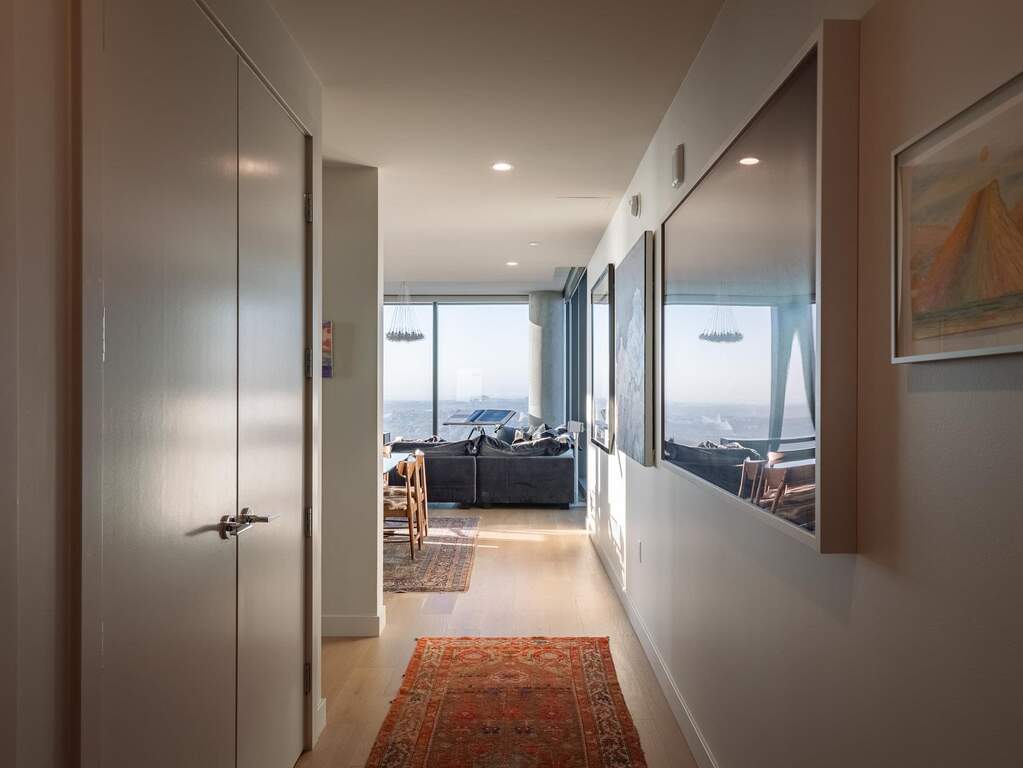 Hallway with light wood-style floors and recessed lighting