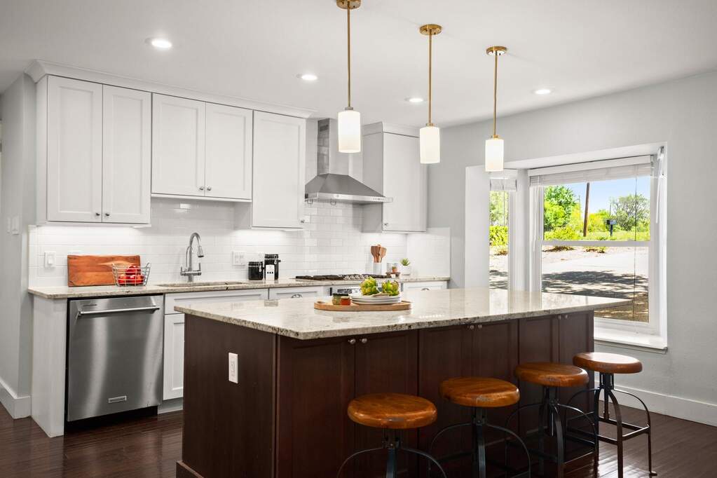 This remodeled kitchen features white and wood cabinetry and granite counters, providing a bright and organized space for meal preparation
