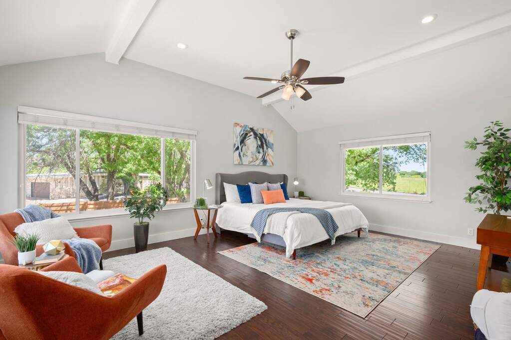 Occupying the entire second floor, the primary suite offers a private level of the home with vaulted ceilings and exposed beams