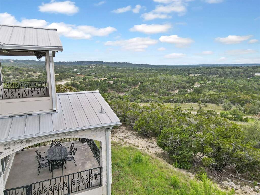 Hilltop House decks offer sweeping views of the Hill Country, with a lower-level dining area and private upper deck.