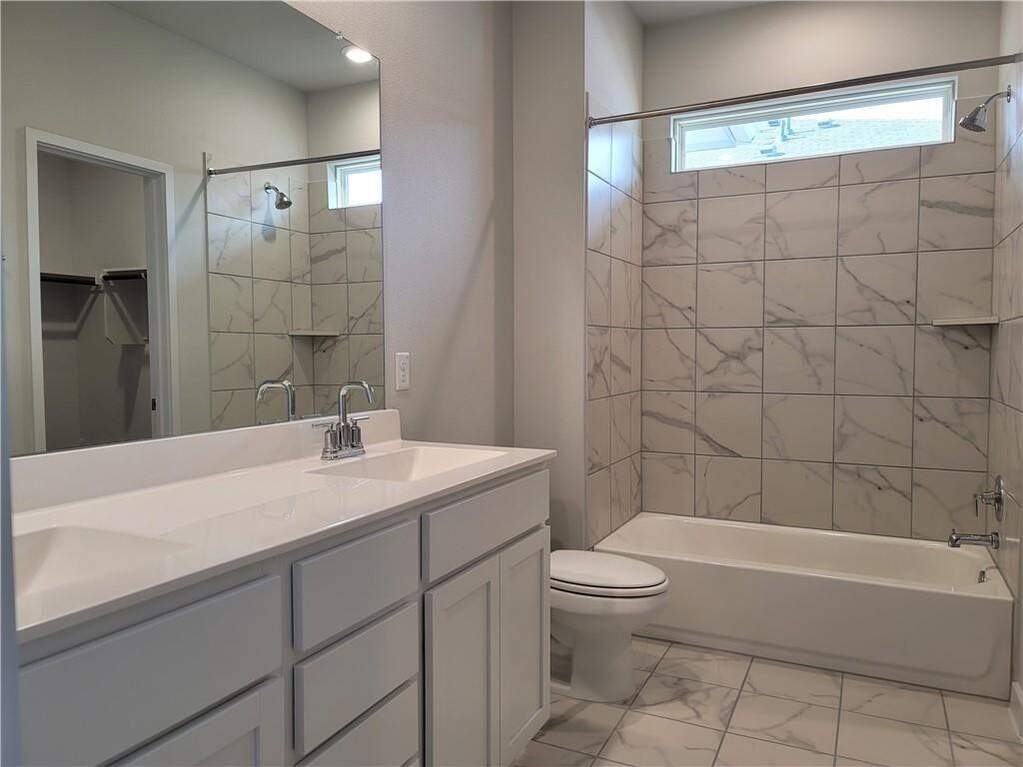Bathroom featuring a dual vanity with a white countertop and chrome fixtures
