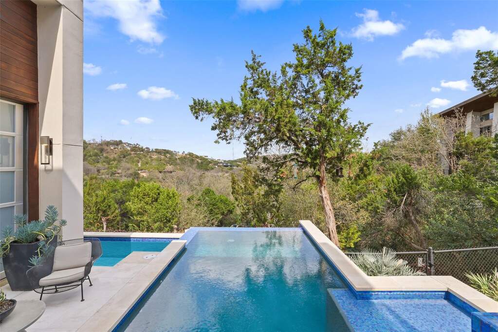 Canyon Views at swimming pool area featuring an negative edge pool, jetted lap pool and spa