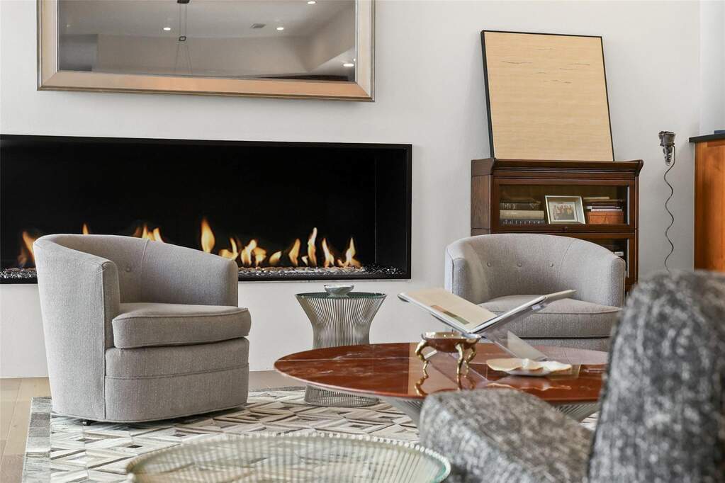 Sitting room featuring a warm lit fireplace and mirror television