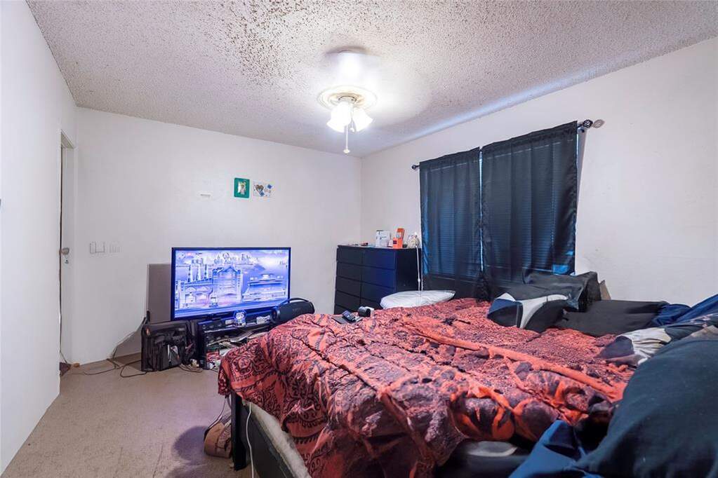 Bedroom with a textured ceiling and a ceiling fan