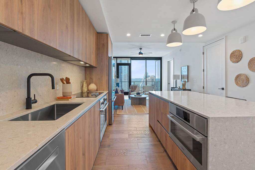 Representative Photo. Kitchen featuring custom Italkraft cabninetry, terrazzo backsplash, waterfall-edge terrazzo countertops, stainless steel Bosch appliances, and pendant lighting above kit