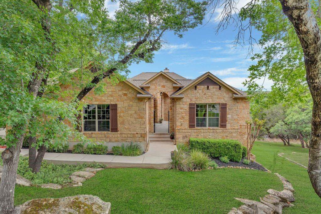 View of front of house featuring a front lawn and stone siding
