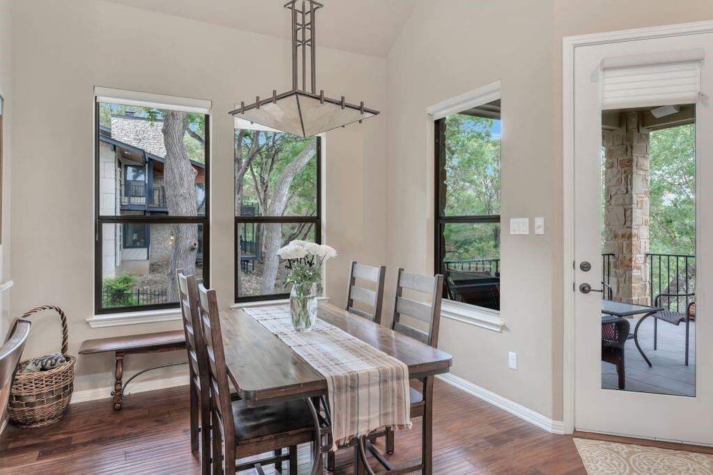 Dining space featuring wood finished floors, healthy amount of natural light, and vaulted ceiling