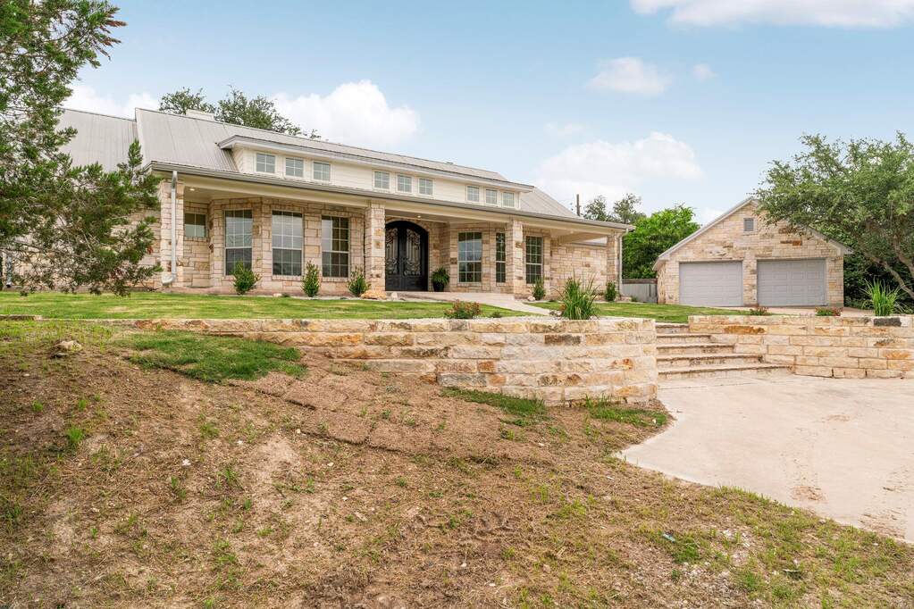 You’ve got a massive driveway leading up to a detached, oversized garage that matches the main house perfectly.