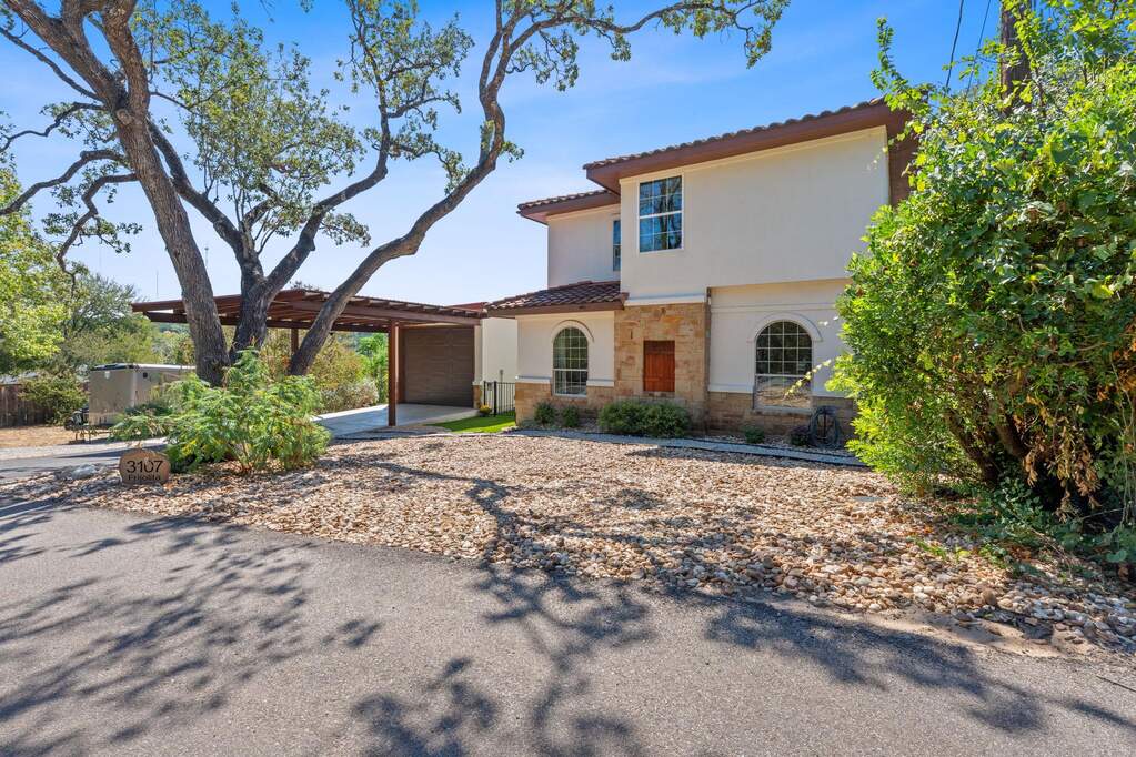 Mediterranean / spanish home with stone siding, stucco siding, concrete driveway, an attached garage, and a tile roof