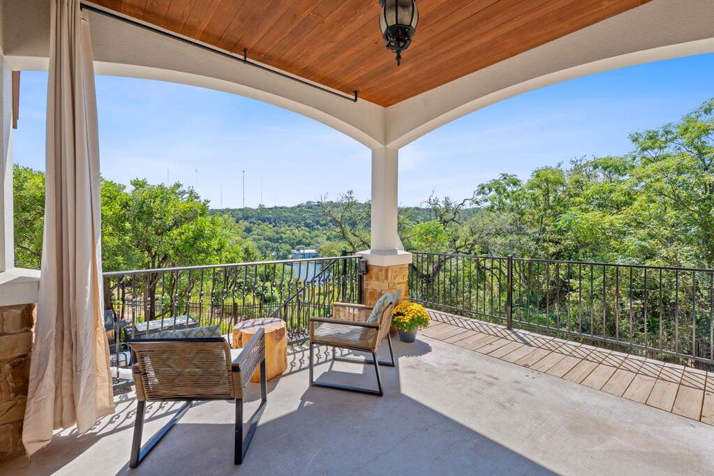 Balcony featuring a wooded view and an outdoor hangout area