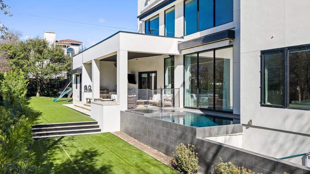 Rear view of property with a playground, a patio, and stucco siding