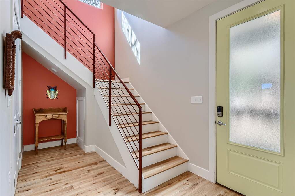 Foyer featuring plenty of natural light, light wood-style flooring, and stairs