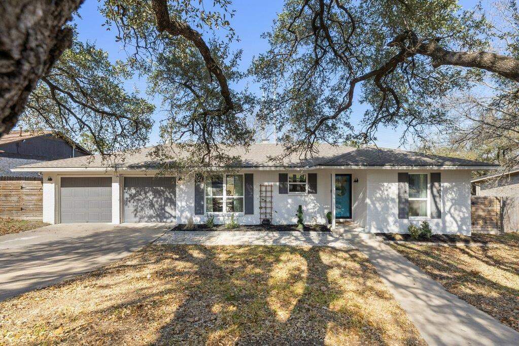 Mature live oak trees in the front yard add shade, beauty, and classic curb appeal