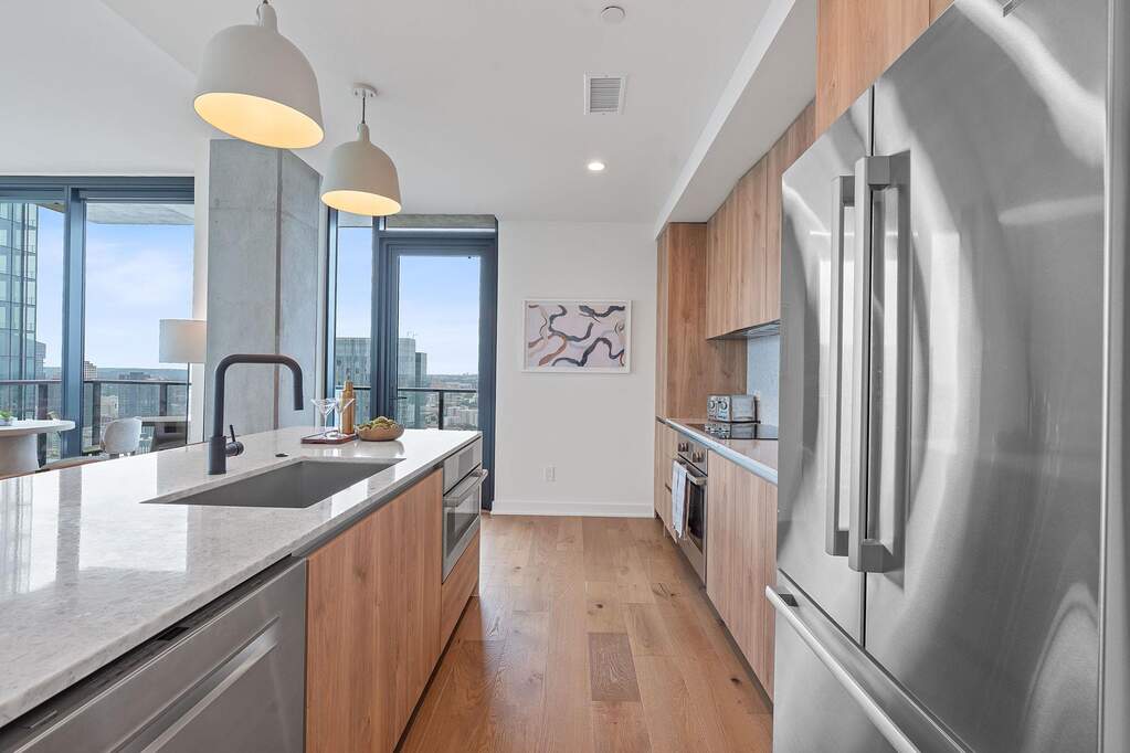 Representative Photo. Kitchen featuring custom Italkraft cabninetry, terrazzo backsplash, waterfall-edge terrazzo countertops, stainless steel Bosch appliances, and pendant lighting above kit