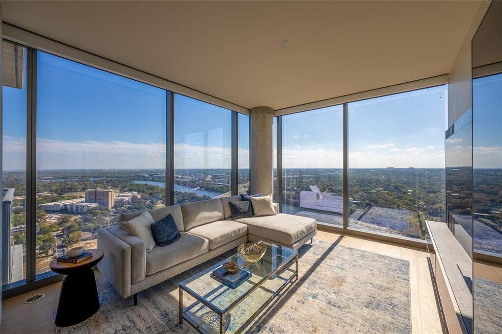Sunroom / solarium featuring floor to ceiling windows, wood finished floors, and a view of city