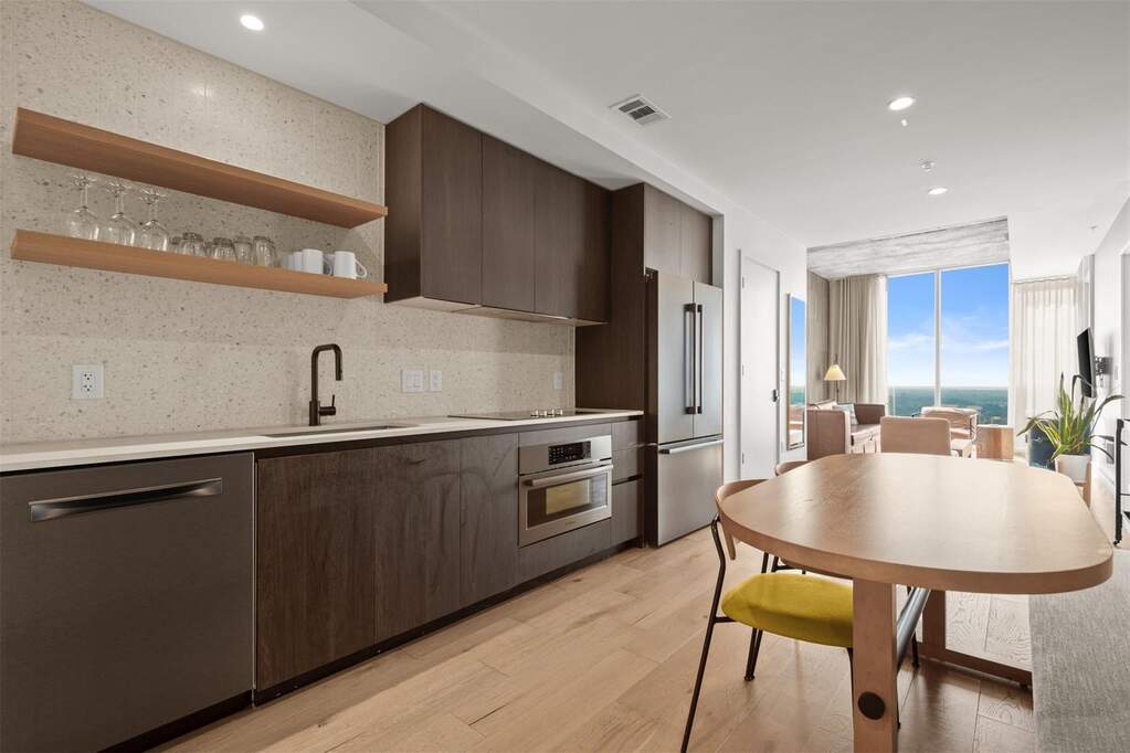 Stainless steel appliances paired with a tile backsplash elevate the space, turning everyday meals into something special
