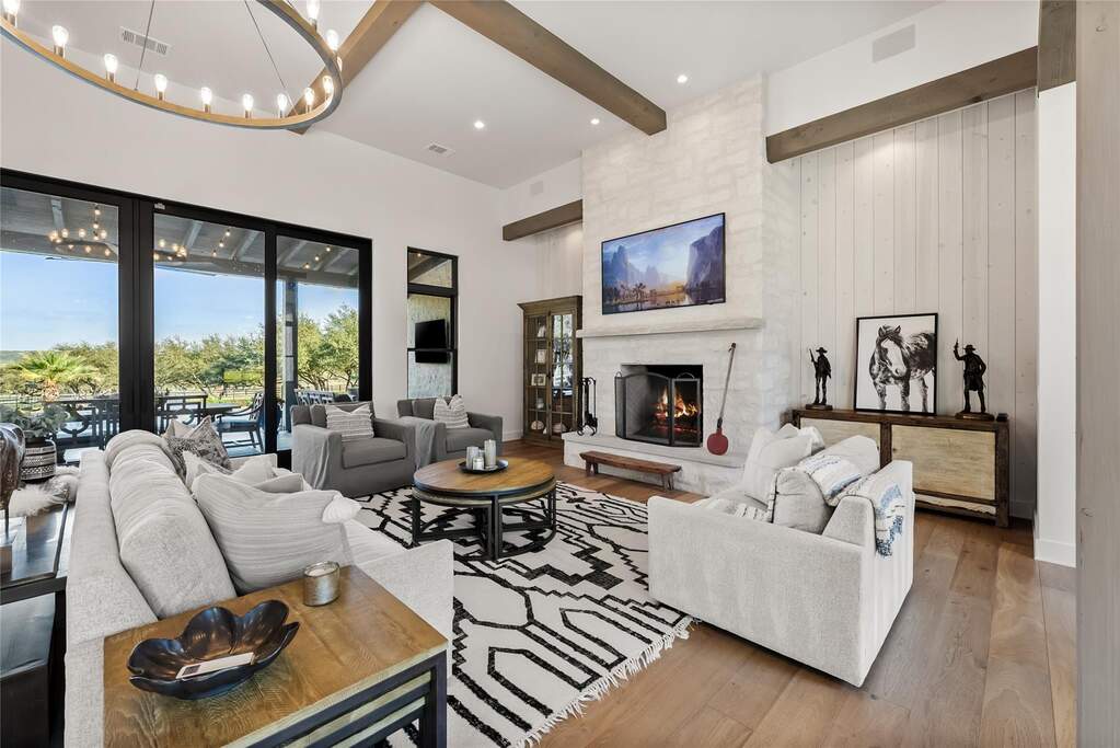 This stunning living space invites you in to relax and enjoy all this home has to offer. The living room is anchored by a magnificent floor-to-ceiling white stone fireplace, providing a stunn
