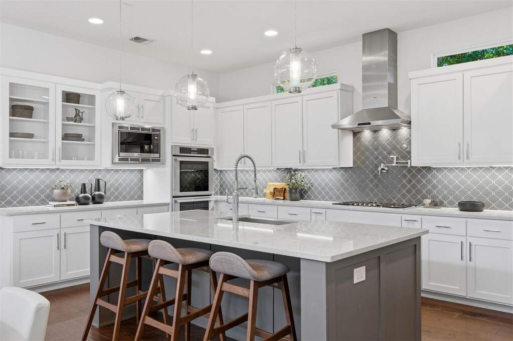 The large center island features a breakfast bar, providing a casual spot to enjoy morning coffee or chat with the chef while dinner is being prepared