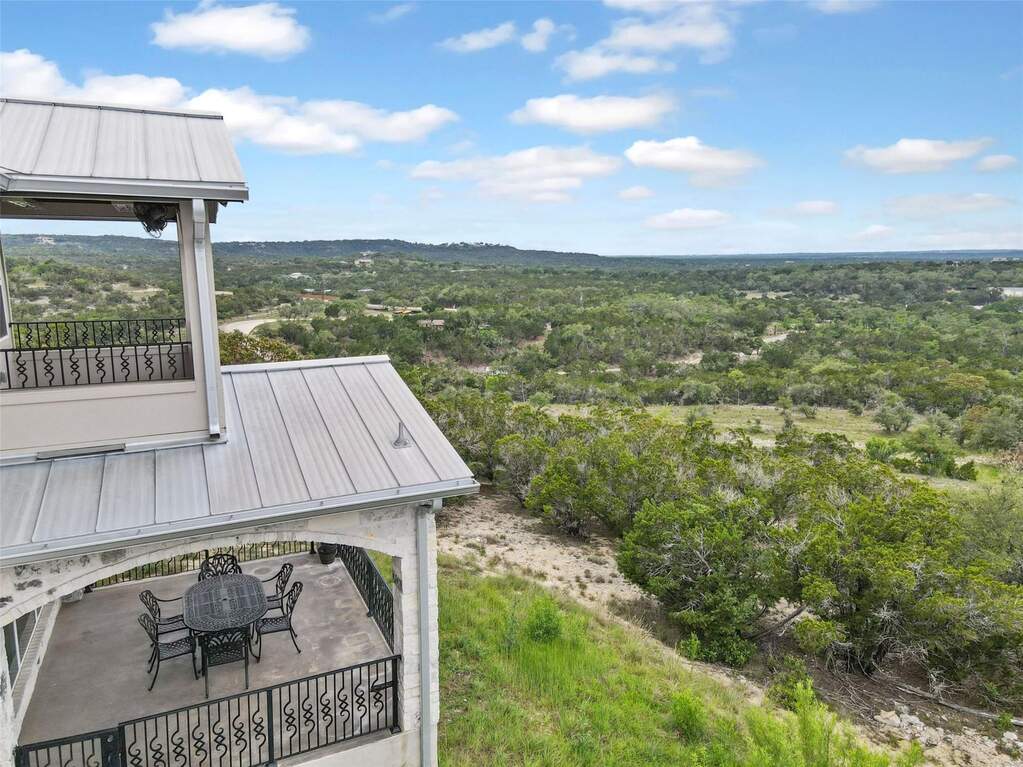 Hilltop House decks offer sweeping views of the Hill Country, with a lower-level dining area and private upper deck.