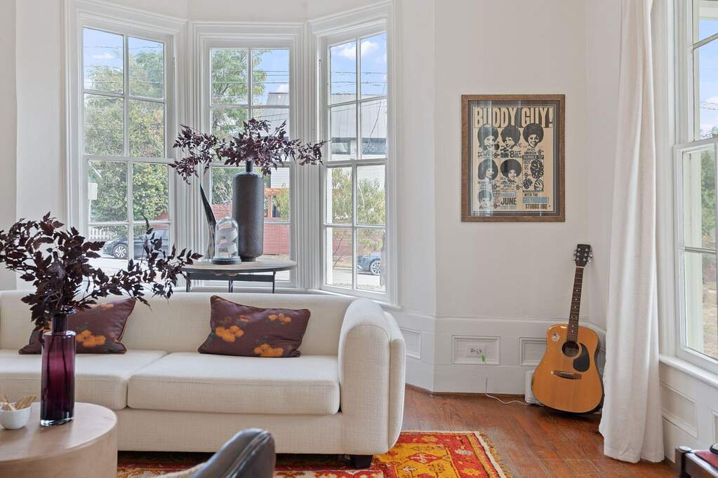 A bright, airy living room with a curved wall of windows—bringing in soft natural light and a sense of peaceful charm.