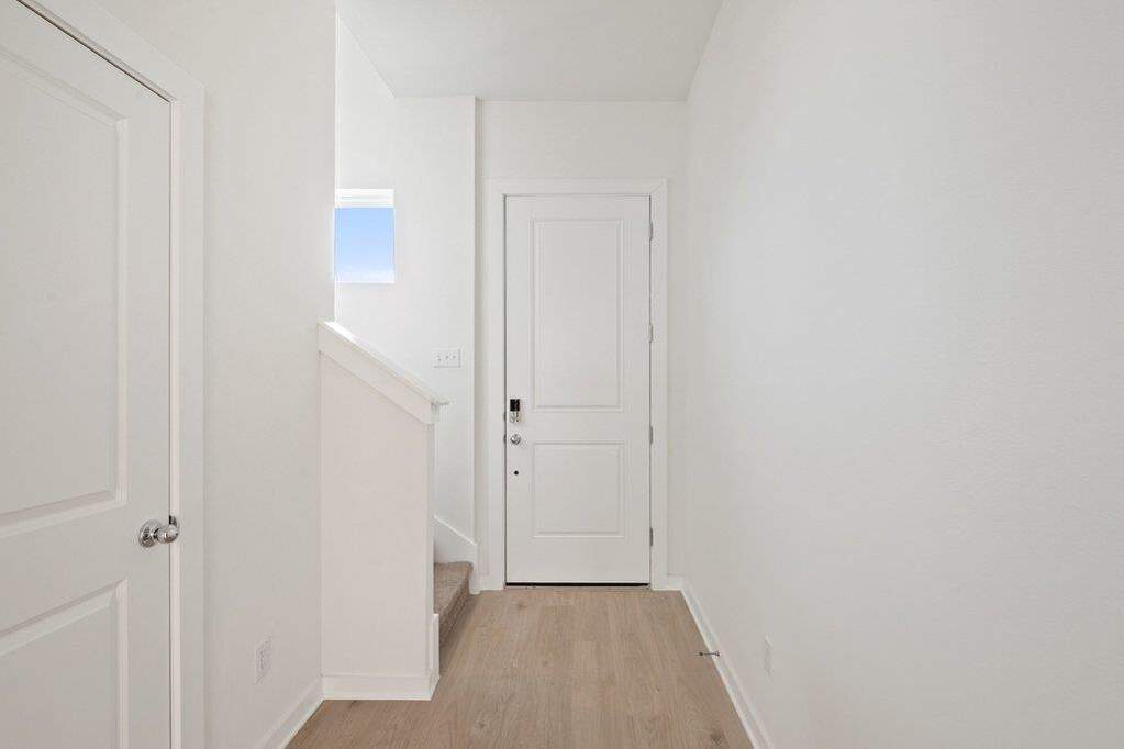 Hall with baseboards and light wood-style flooring