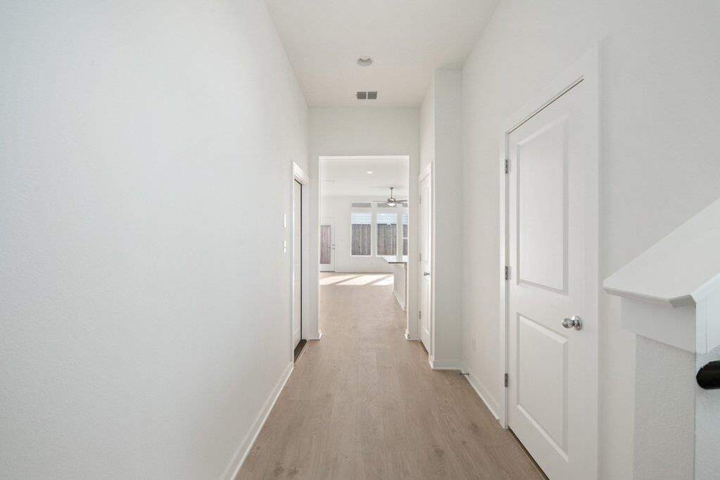 Hall with light wood-style floors and baseboards