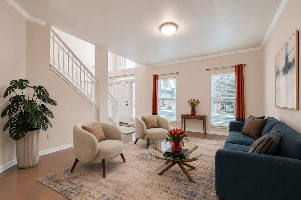 Hardwood flooring and crown molding accent this inviting living room, offering abundant natural light and an elegant entry.