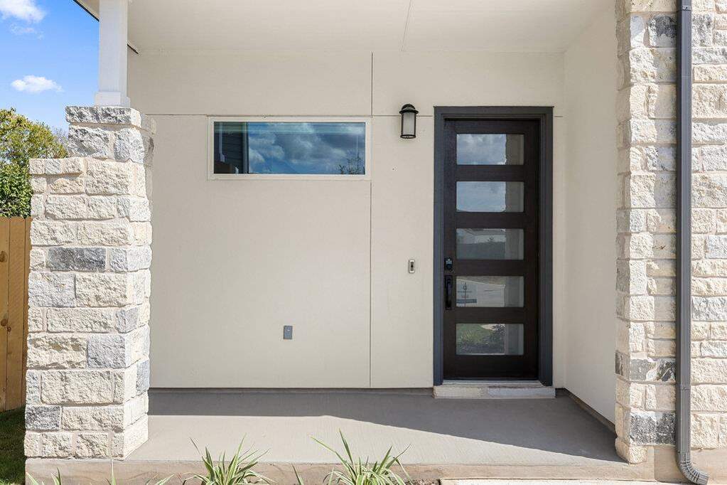Property entrance featuring stone siding and stucco siding