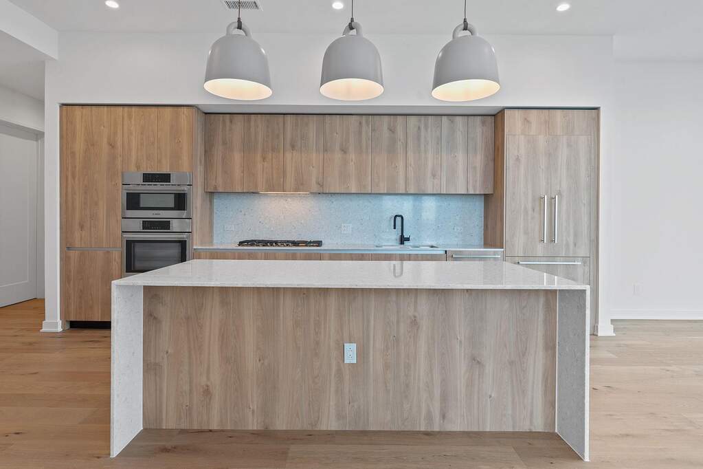 Kitchen featuring light stone countertops, decorative backsplash, light wood-style flooring, modern cabinets, and recessed lighting
