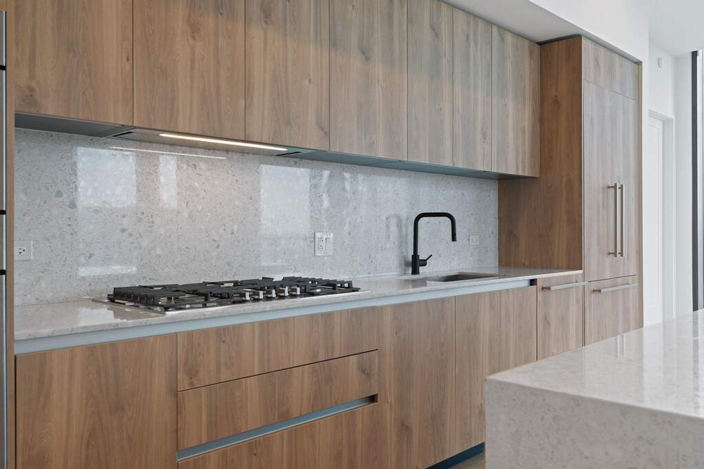 Kitchen featuring modern cabinets, light stone countertops, backsplash, stainless steel gas stovetop, and Italkraft cabinetry