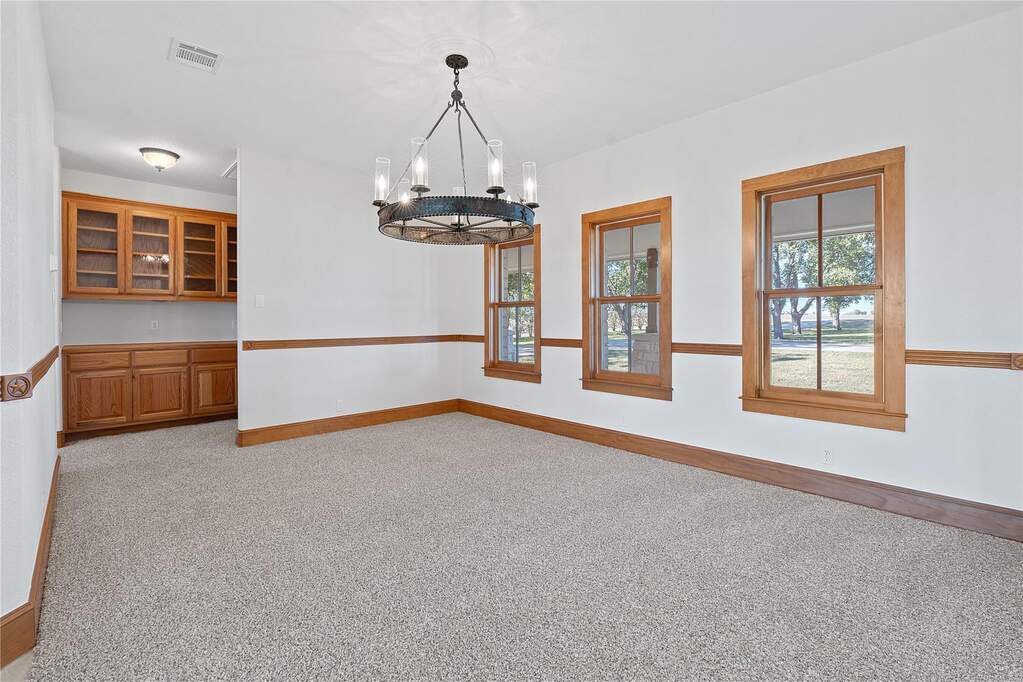 Unfurnished dining area with light carpet and a chandelier