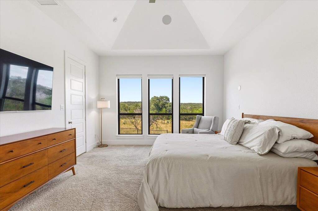 A primary suite with tall ceilings, soft natural light, and backyard views that make the room feel instantly calm.