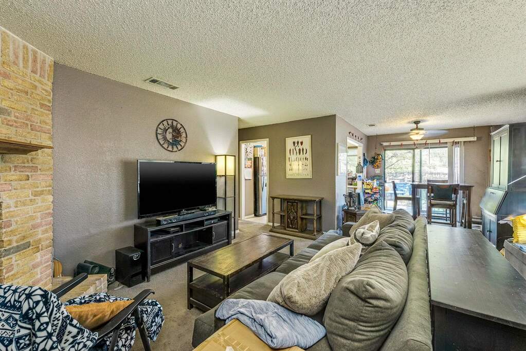 Carpeted living room featuring a textured ceiling