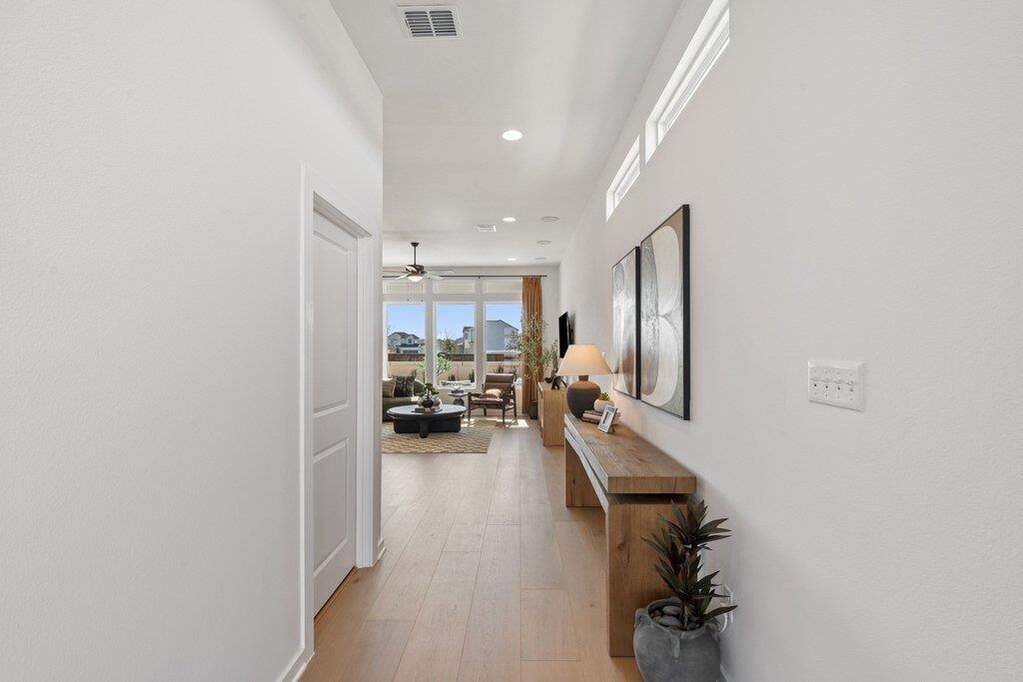 Long hallway featuring wood-finish flooring and recessed lighting