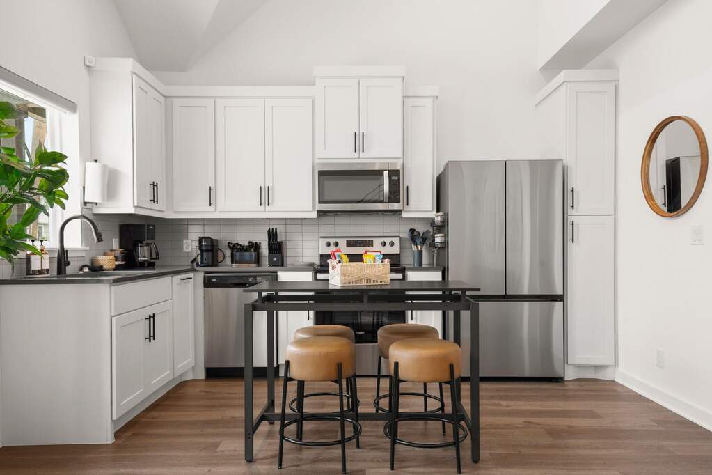 The modern kitchen features stainless steel appliances, room for an island or small table, and a large window to let the light shine through as you're preparing your morning breakfast and cof