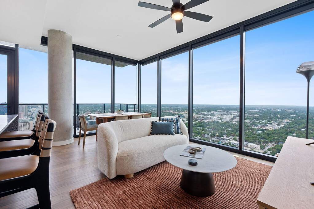 Representative Photo. Open Concept living room with 7.5" wide Bella Cera hardwood flooring, recessed lighting, ceiling fan, and a balcony off the living room with a North East view