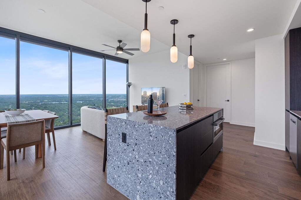 Representative Photo. Kitchen featuring custom Italkraft cabninetry, terrazzo backsplash, waterfall-edge terrazzo countertops, black stainless steel Bosch appliances, and pendant lighting abo